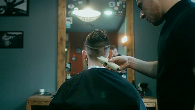 一名蓄着胡须的年轻英俊的白人男子正在一家现代理发店里理发视频下载