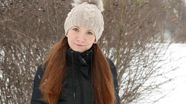 女人肖像在雪中，女士直视相机带着淡淡的微笑视频素材