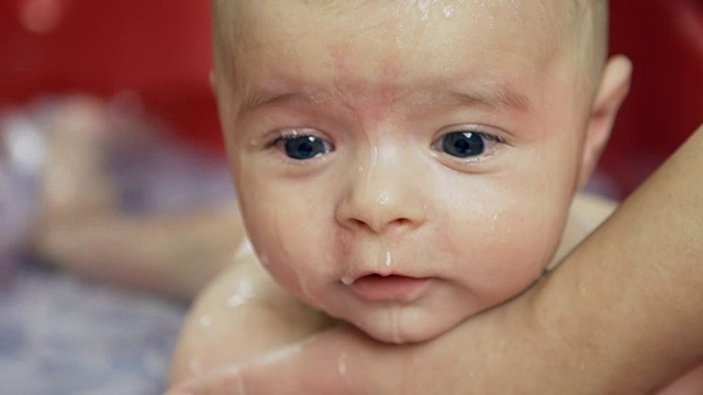 用红色的婴儿浴给婴儿洗澡。视频素材