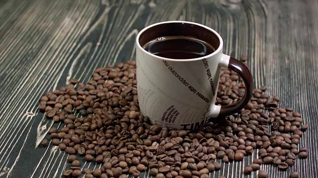 特写咖啡杯与烤咖啡豆在木制背景视频素材