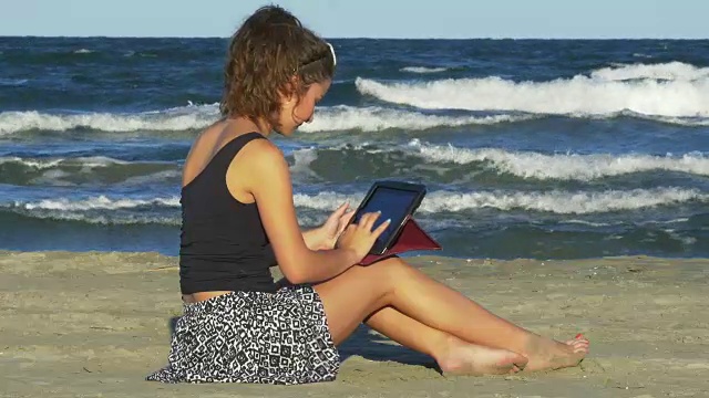 一个女人在海边用平板电脑聊天视频素材