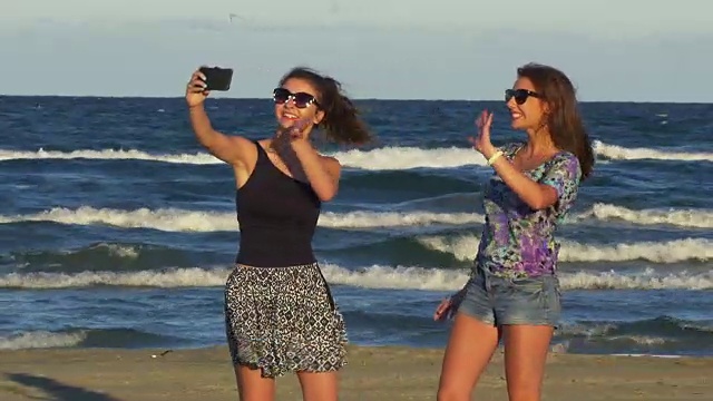 美丽的年轻女子在沙滩上进行视频通话视频素材