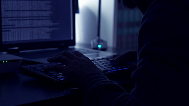详细说明了黑客的双手在黑暗中在电脑上打字视频素材