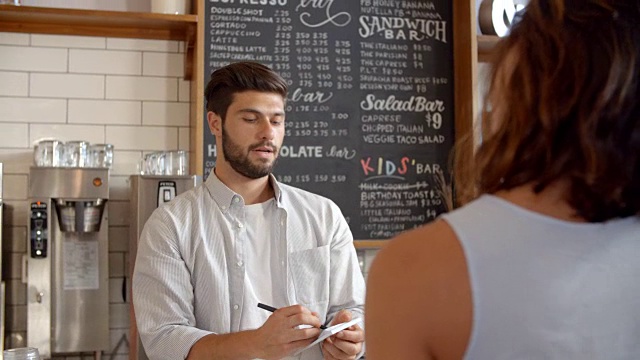 在咖啡店接受顾客刷卡付款的咖啡师视频素材