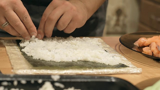 特写厨师的手烹饪和准备亚洲食物和寿司在餐厅厨房。视频素材