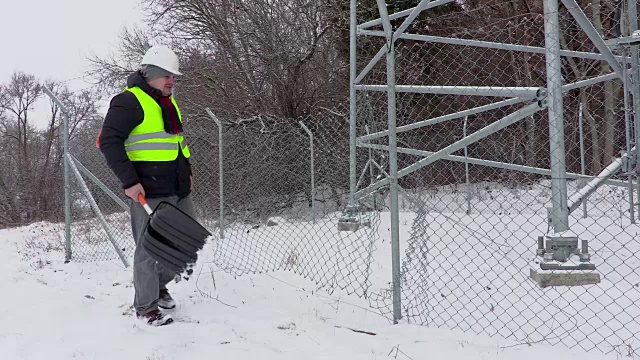 工人用雪铲靠近破损的栅栏视频下载