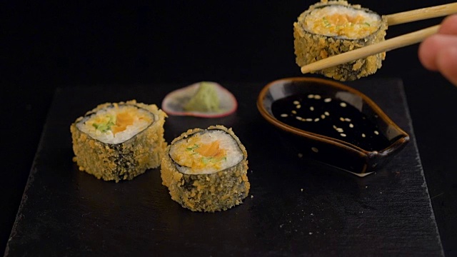 用筷子从深色盘子里夹寿司卷视频素材