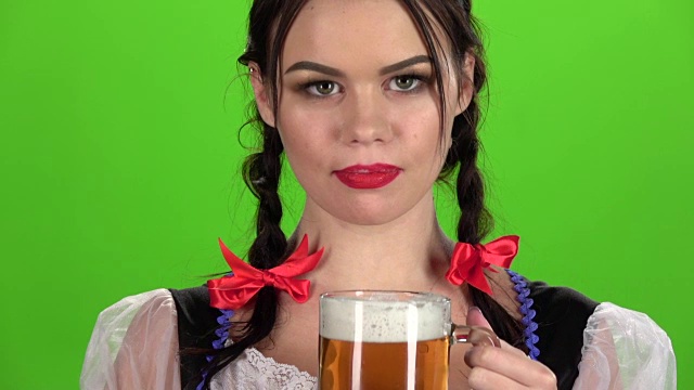 女孩喝啤酒和性感舔。绿色的屏幕。慢动作视频素材