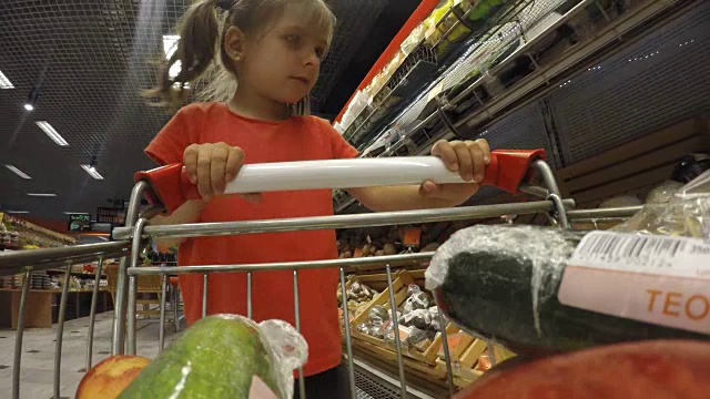 可爱的小女孩在蔬菜杂货店挑选蔬菜视频素材