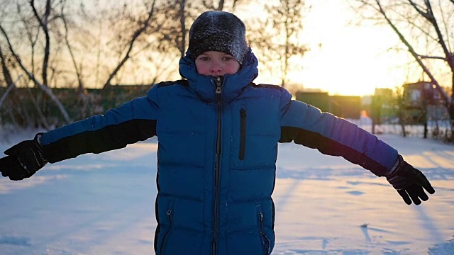 孩子挥手打招呼在冬季公园日落视频素材
