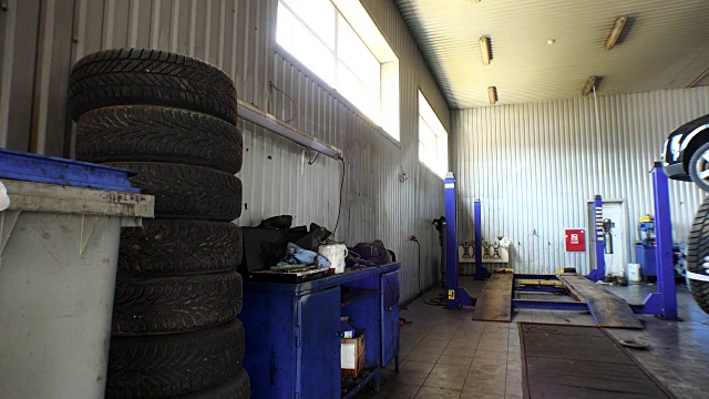 在车库里堆放磨损轮胎的人。换胎和储存服务。视频下载