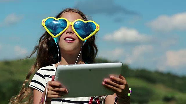女孩戴着大墨镜和平板电脑通过skype交流视频素材