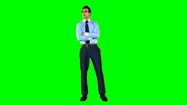 商人双臂交叉站在绿色背景下视频素材