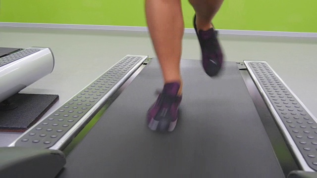 女性在健身房跑步机上慢跑和跑步。年轻女性在有氧运动中锻炼。女孩们穿着运动鞋在运动俱乐部室内训练。近距离视频素材