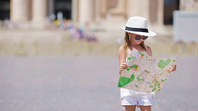 可爱的小女孩拿着旅游地图在圣彼得大教堂广场，意大利。快乐的小孩享受意大利假期在欧洲视频下载