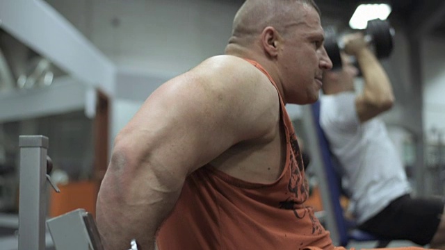 在健身房锻炼的肌肉男，在健身房举重的男人。视频下载