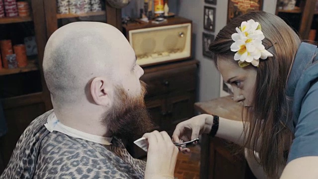 女理发师在理发店里用剪刀修剪顾客的胡子视频素材
