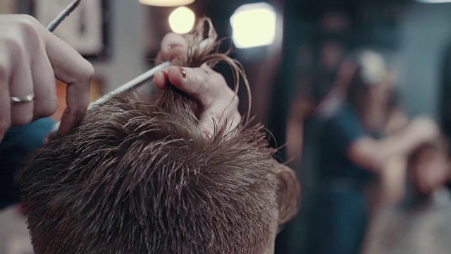 女理发师用剪刀和梳子剪着病人的耳朵，近处视频素材