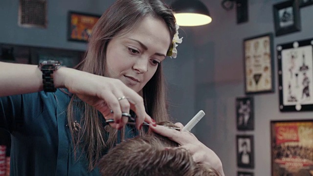 女理发师用剪刀和梳子剪着病人的耳朵，近处视频素材