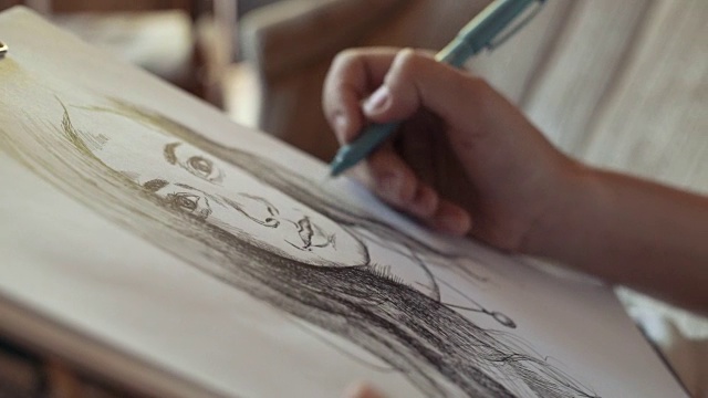 一个年轻女子在咖啡馆里画肖像，近距离看视频下载