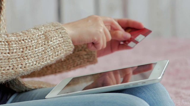 用信用卡在数字平板电脑上购物的女人视频素材