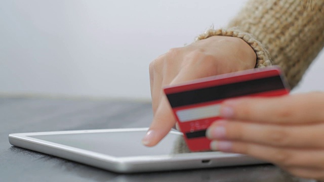 用信用卡在数字平板电脑上购物的女人视频下载