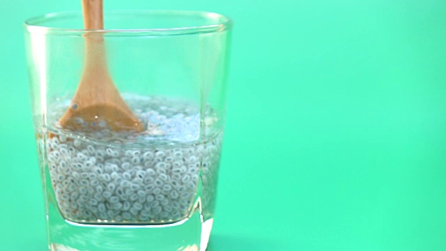 奇亚种子浸泡在水杯在绿色屏幕的慢动作视频下载