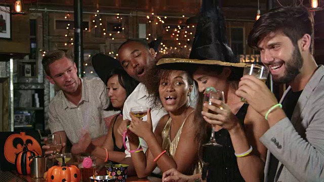 朋友们享受万圣节派对在酒吧祝酒词，拍摄于R3D视频素材