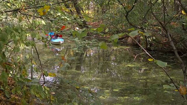 女孩们在森林河的皮划艇里游泳视频素材