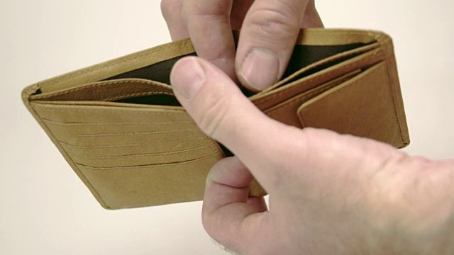 一个棕色的空钱包和一个男人的手视频素材