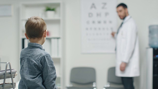 小男孩在医生的办公室里检查他的视力。一个男孩的房间。视频素材