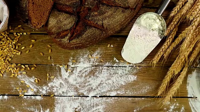 木桌上放着面包、麦穗和面粉，手推车，俯视图视频素材