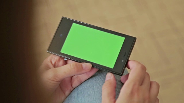 手持绿色屏幕智能手机的漂亮女人视频下载