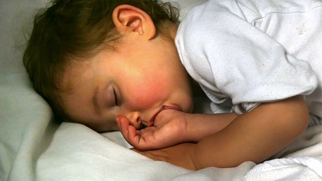 睡觉的孩子，吮吸的婴儿的拇指，手指视频下载