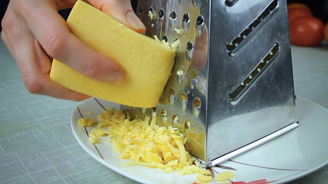 帕尔马干酪放在厨房刨丝器上视频素材