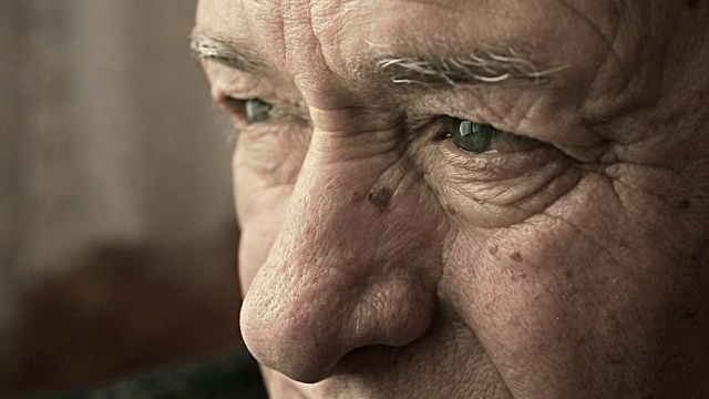 特写悲哀而忧郁的老人的眼睛:担心和害怕的老人视频素材