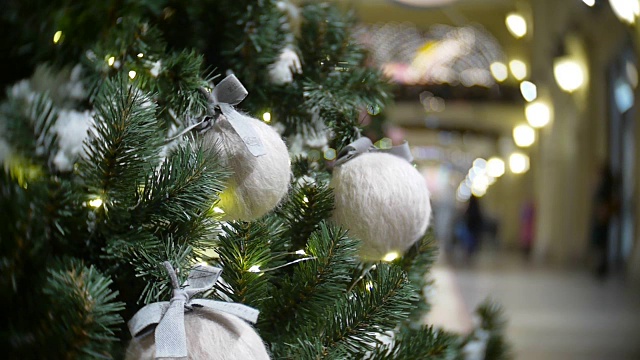 白色的羊毛球和灯。新年和抽象模糊的购物中心背景与圣诞树装饰视频素材