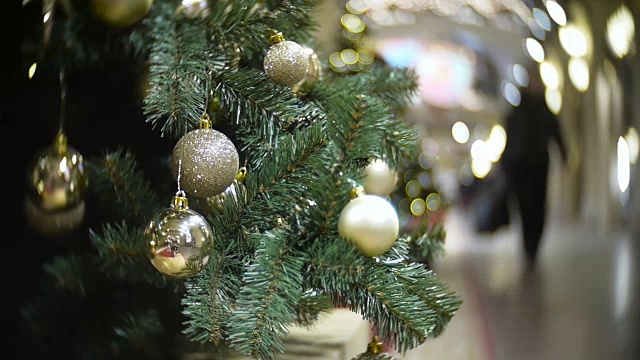 金色的磨砂球和镜子球。新年和抽象模糊的购物中心背景与圣诞树装饰视频素材