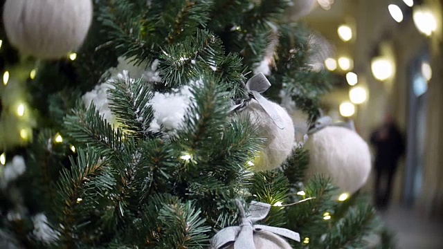 滑块视图的白色羊毛球和灯。新年和抽象模糊的购物中心背景与圣诞树装饰视频素材