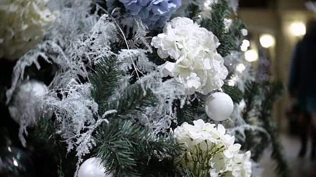 滑块视图的白色球和花。新年和抽象模糊的购物中心背景与圣诞树装饰视频素材