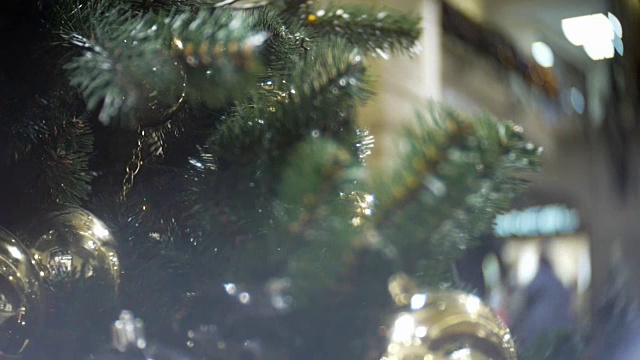 滑进金色的磨砂球和镜子球。新年和抽象模糊的购物中心背景与圣诞树装饰视频素材