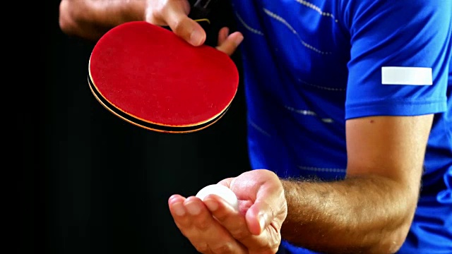 一个在黑色背景上发球的乒乓球的特写视频下载