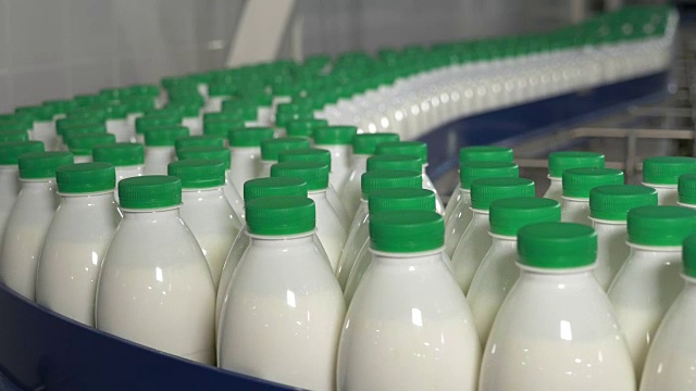 装着牛奶的塑料瓶在牛奶厂的传送带上移动视频素材