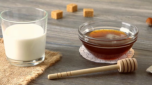牛奶，蜂蜜和新鲜的长棍面包放在质朴的木桌上。农村的早餐视频下载