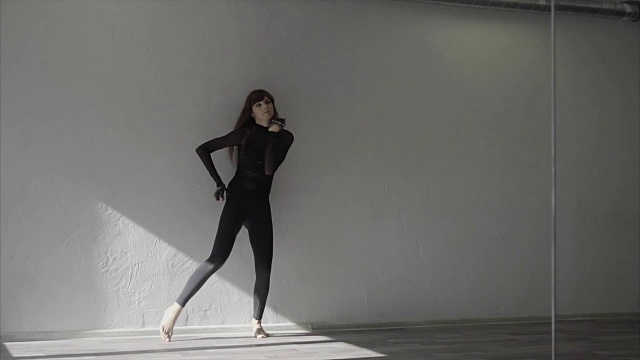 年轻漂亮的女人穿着黑色衣服在录音室里慢动作跳舞视频下载