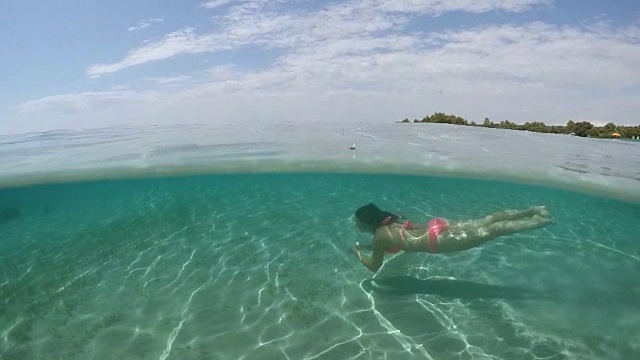 水下:可爱的棕色长发女孩在水下游泳视频下载