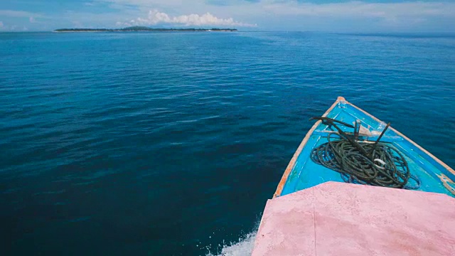 巴厘岛无边无际的海洋令人叹为观止，前方是游艇的讲坛。船在海上游泳，这是令人难以置信的景象。印度尼西亚的海洋景观碧绿的水和蓝色的天空视频素材