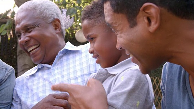 小黑人男孩和爸爸、叔叔、爷爷在户外玩视频素材