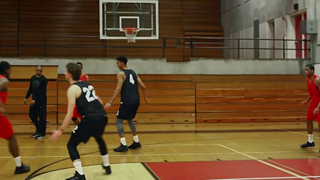 在一场比赛中，随着篮球运动员在场上的动作，球员投进一个球视频下载
