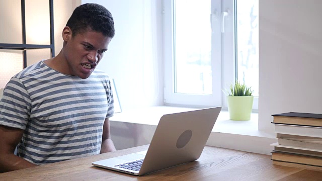 年轻黑人在笔记本电脑上工作时大喊大叫视频素材
